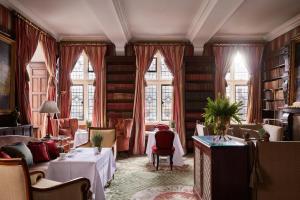 a dining room with tables and chairs and windows at Milestone Hotel Kensington in London