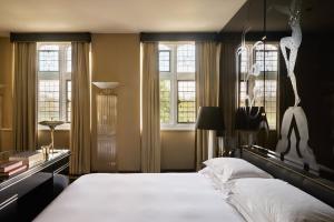 a bedroom with a large bed and windows at Milestone Hotel Kensington in London