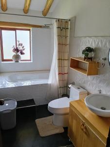 a bathroom with a tub and a toilet and a sink at Hermosa casa confortable en el Valle Sagrado in Calca
