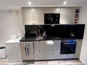 a kitchen with a sink and a microwave at Modern villa apartment with free parking in Sollentuna