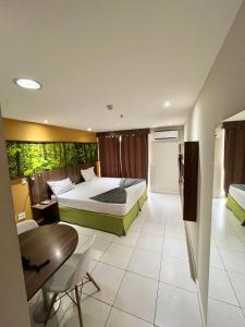 ein Schlafzimmer mit einem Bett, einem Schreibtisch und einem Tisch in der Unterkunft ApartHotel Centro de Nova Iguaçu in Nova Iguaçu