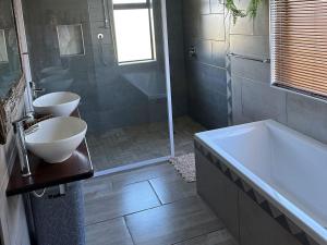 une salle de bain avec deux lavabos et une baignoire dans l'établissement Vaal Dam Getaway, à Denysville