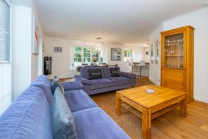a living room with a blue couch and a table at Gode Stuv in Westerland
