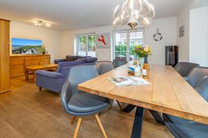 a dining room with a wooden table and chairs at Gode Stuv in Westerland