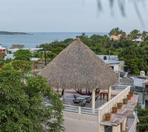a view of a resort with a straw roof at Casa Laani in Puerto Escondido
