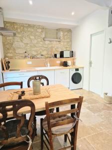 a kitchen with a wooden table and chairs and a counter at Gîte VITAL Rivière - Charming cottage in Peyrus