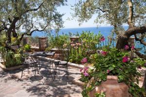 a patio with a table and chairs and flowers at Hotel Arenauta in Gaeta +39 photos