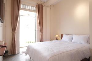 a bedroom with a large bed and a large window at DAINOI Hue Homestay in Thôn Kim Long (1)