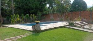 einen Hinterhof mit einem Pool im Gras in der Unterkunft Rancho PÔR do Sol in Benevides