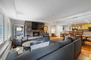 a living room with a large couch and a fireplace at Lodge Tower 487 Three Bedroom Residence in Vail
