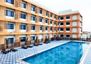 a hotel with a swimming pool in front of a building at Escale International Hotel in Djibouti