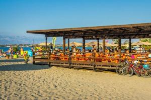 a restaurant on the beach with bikes parked on the sand at Studio apartman Kata Nin in Nin