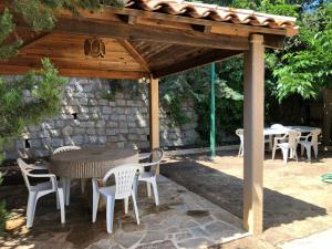 a wooden pergola with a table and chairs under it at VILLA route des sanguinaires in Ajaccio +7 photos