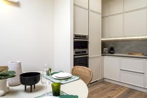 a kitchen with white cabinets and a table at Olivuzza a Santa Margherita by Wonderful Italy in Santa Margherita Ligure