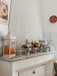 a counter with vases of flowers and a clock at Hortensia Home in Iglesias