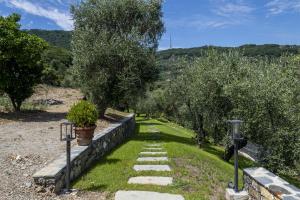 a garden with a stone path and trees at Olivuzza a Santa Margherita by Wonderful Italy in Santa Margherita Ligure