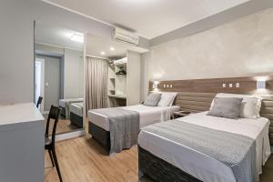 a hotel room with two beds and a mirror at Valerim Florianópolis in Florianópolis +78 photos