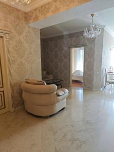 a living room with a couch and a chandelier at Liberty Square Accommodation I in Tbilisi City