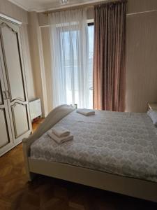 a bedroom with a bed with two towels on it at Liberty Square Accommodation I in Tbilisi City