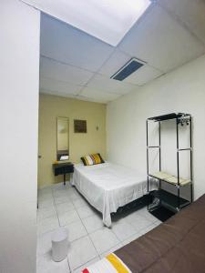 ein Zimmer mit einem Bett und einem Regal darin in der Unterkunft Hostal 5224 in San Salvador