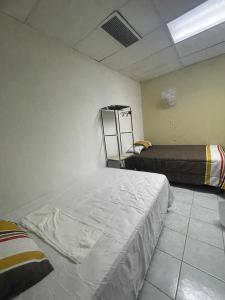 1 Schlafzimmer mit 2 Betten in einem Zimmer mit einer Decke in der Unterkunft Hostal 5224 in San Salvador