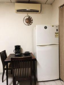 eine Küche mit Tisch und Kühlschrank sowie Tisch und Stuhl in der Unterkunft Hostal 5224 in San Salvador