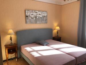 a bedroom with a bed and two lamps and a painting on the wall at VILLA route des sanguinaires in Ajaccio