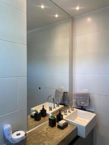 a bathroom with a sink and a mirror at Apartamento Centro Búzios Luxo in Búzios +27 photos