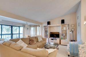 a living room with a couch and a tv at Pool and Ocean Access Palm Beach Gardens Condo in Palm Beach Gardens