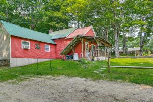 una casa rossa con un tetto verde e una recinzione di Cottage Less Than 8 Mi to Gore Mountain in Bakers Mill! a Bakers Mills