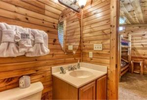 a bathroom with a sink and a mirror in a log cabin at Day Dreamer Cabin W Views By Beyond Expectations in Gatlinburg +36 photos