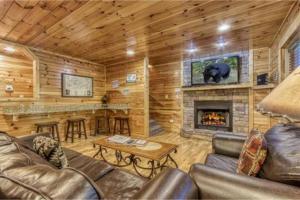 a living room with a fireplace in a log cabin at Day Dreamer Cabin W Views By Beyond Expectations in Gatlinburg