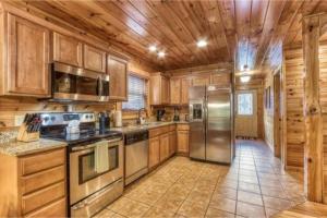 a kitchen with wooden cabinets and stainless steel appliances at Day Dreamer Cabin W Views By Beyond Expectations in Gatlinburg