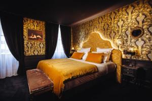 a bedroom with a bed with a yellow bedspread at Madame C - Hôtel Particulier in Strasbourg