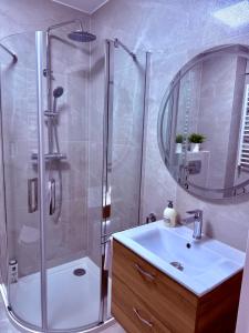 a bathroom with a shower and a sink and a mirror at LOFT APARTAMENT II Kępno in Kępno +3 photos