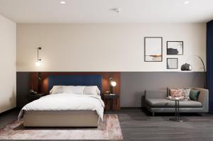 een slaapkamer met een bed, een bank en een stoel bij Crowne Plaza Istanbul - West in Istanbul