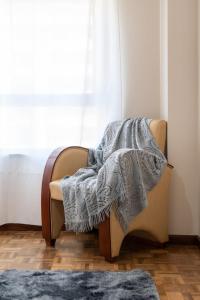 een deken die op een stoel voor een raam ligt bij White Charm by the Sea in Viana do Castelo +43 foto's