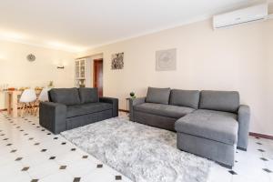 een woonkamer met 2 banken en een tapijt bij White Charm by the Sea in Viana do Castelo