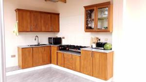 a kitchen with wooden cabinets and a stove at Given House in Tuvaila