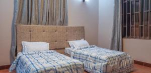 a room with two beds and two windows at Given House in Tuvaila