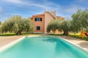 a swimming pool in front of a house with trees at Villa Mira Exclusive with Pool- Noto Sicily in Noto Marina
