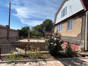 a house with a fence in front of it at Adventure Guest House in Pokrovka +9 photos