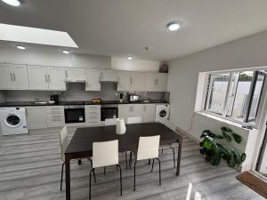 ロンドンにあるStreatham Roomsのキッチン(黒いテーブル、白いキャビネット付)