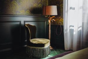 a chair next to a lamp in a room at Madame C - Hôtel très particulier in Strasbourg +49 photos
