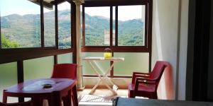 Ein Tisch und Stühle vor einem Fenster mit Blick auf die Berge in der Unterkunft Za Rosa in Aieta