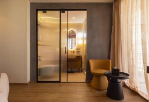 a room with a glass door and a yellow chair at Le Square By Onomo Collection in Casablanca