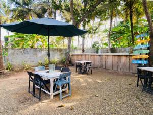 a table with chairs and an umbrella on a patio at Chill Hostel Madiha in Matara