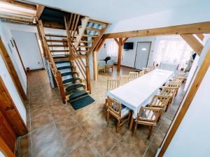 Zimmer mit einem Tisch, Stühlen und Treppen in der Unterkunft Casa din Zori in Muntele Băişorii