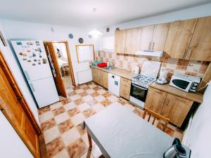 eine Küche mit Holzschränken und einem weißen Kühlschrank in der Unterkunft Casa din Zori in Muntele Băişorii + 9 Fotos