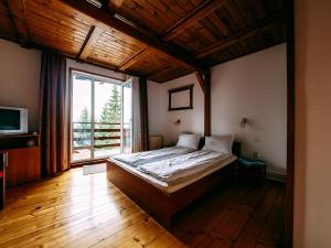 ein Schlafzimmer mit einem Bett und einem großen Fenster in der Unterkunft Casa din Zori in Muntele Băişorii